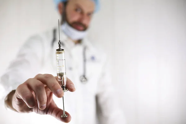 Médico barbudo louco em um casaco branco e seringa velha — Fotografia de Stock