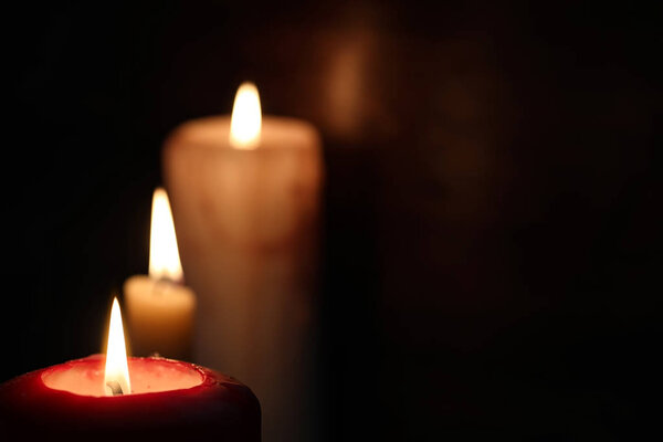 Горящая свеча пламени в темноте
