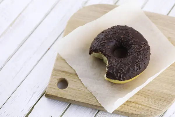 Donut de chocolate em um fundo branco de madeira — Fotografia de Stock