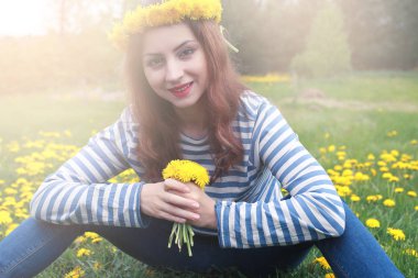 Sarı dandelions çayırda güneşli bir dinlenme kız