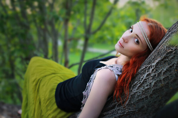 Girl in the spring walks through the apple alley in the evening