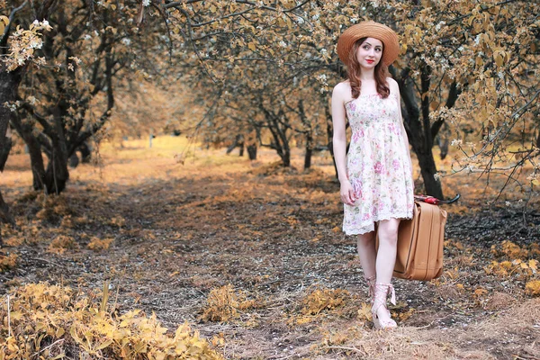 Flicka med läder resväska för resor i höst parken på promenad — Stockfoto
