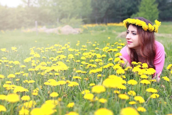 Girl resting on a sunny day in meadow of yellow dandelions — Stock Photo, Image