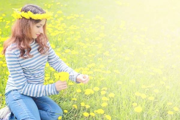 Dziewczyna na słoneczny dzień w łąka żółty mniszek lekarski — Zdjęcie stockowe