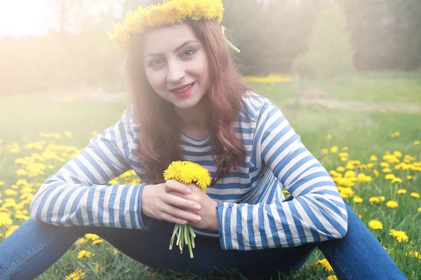 Sarı dandelions çayırda güneşli bir dinlenme kız