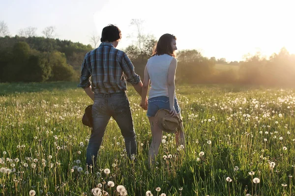 Bahar akşamında gün batımında yürüyen iki genç insan.