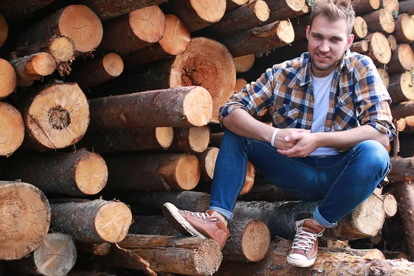 Bir adam fabrikada ahşap işleme, günlükleri testere ile kesme