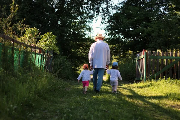 Двоє дітей ходять дідусем — стокове фото