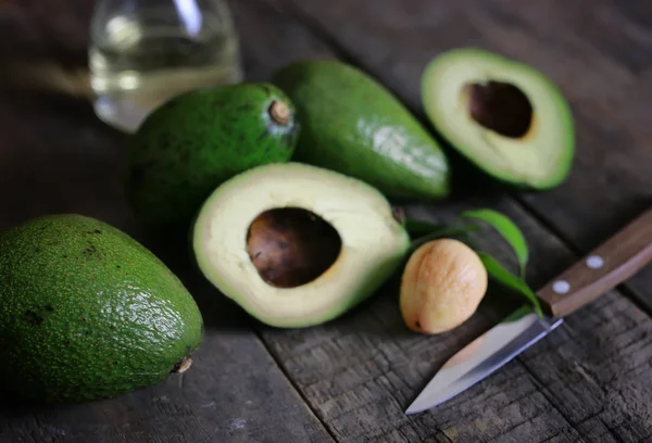 Avocado and oil on wooden background — Stock Photo, Image