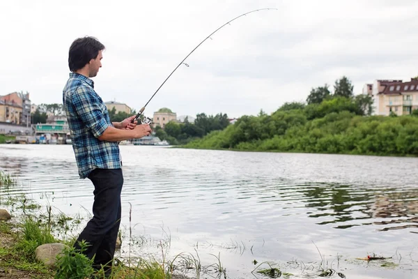 Un hombre con barba está pescando en el río — Foto de Stock