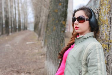 Sonbaharda parkta kulaklıklı bir kadın.
