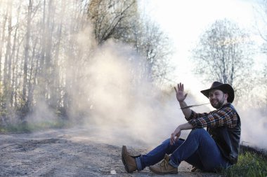 Bir kovboy yolda kalın bir duman