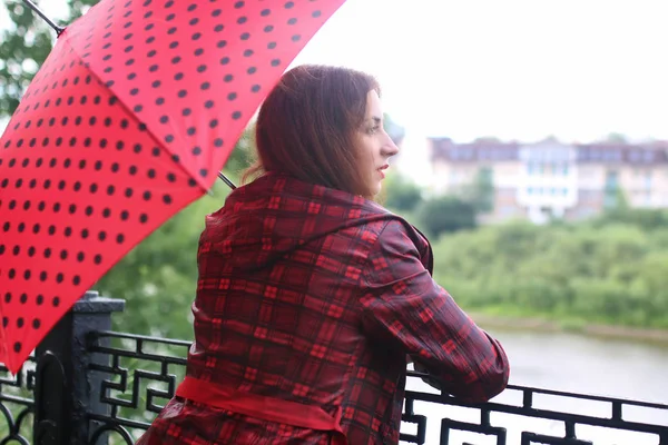 Жінка з парасолькою червона на вуличному дереві — стокове фото