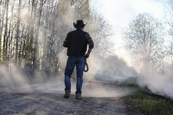 A cowboy in a thick smoke on the road — Stock Photo, Image