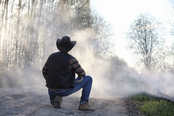 Um cowboy em uma fumaça grossa na estrada — Fotografia de Stock