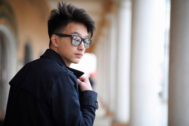 Asya genç adam sokakta bir ceket