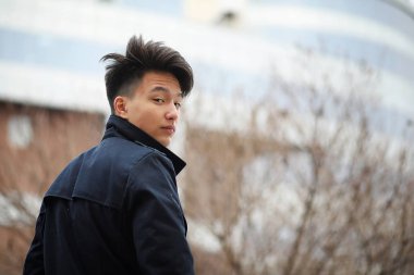 Asya genç adam sokakta bir ceket