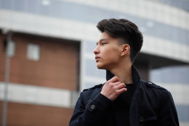 Asya genç adam sokakta bir ceket