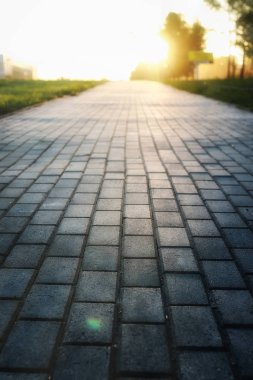 Gri kaldırım taşı yol uzakta umudu'nde Günbatımı gider.