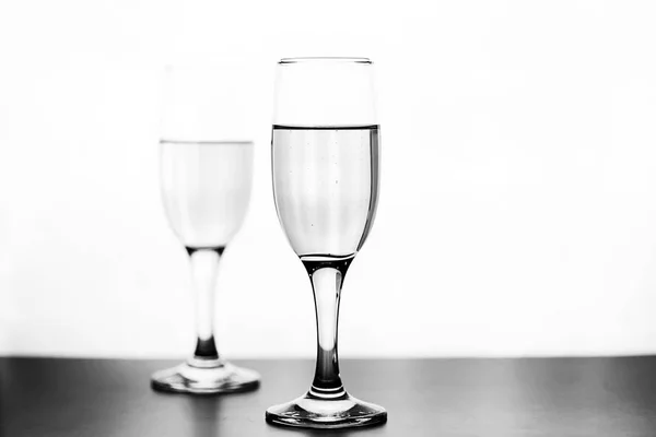 Monochrome photo of champagne on white table on white background — Stock Photo, Image