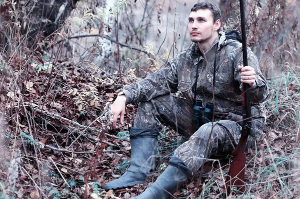 Ένας άνδρας στο καμουφλάζ και με ένα τουφέκι κυνήγι σε ένα δάσος για ένα sp — Φωτογραφία Αρχείου