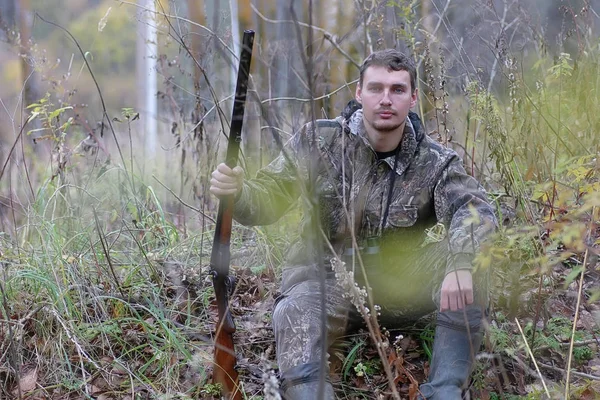 Homme en camouflage et armé dans une ceinture forestière sur un jabot de printemps — Photo