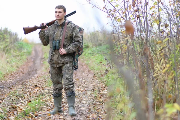 Uomo in camuffamento e con le pistole in una cintura forestale su una molla hun — Foto Stock