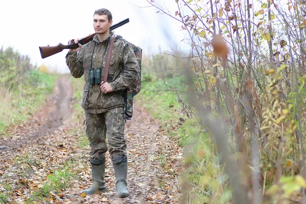 Hombre en camuflaje y con armas en un cinturón forestal en un hun de primavera — Foto de Stock