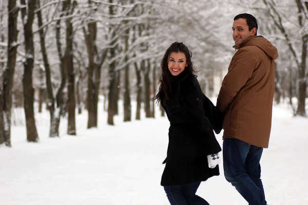 Молодая пара гуляет в зимнем парке — стоковое фото