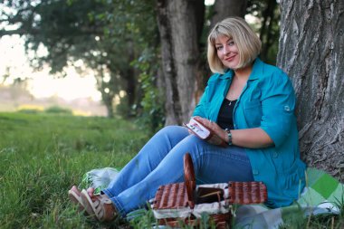 kadınla çimenlerin üzerinde kitapla Park