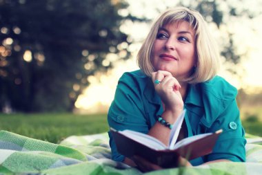 kadınla çimenlerin üzerinde kitapla Park