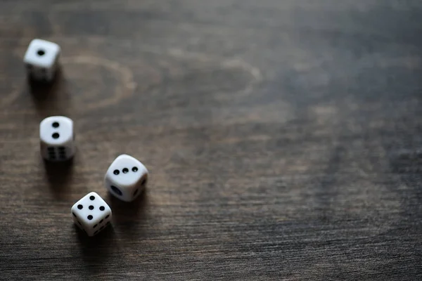 White dices on a brown wooden texture table