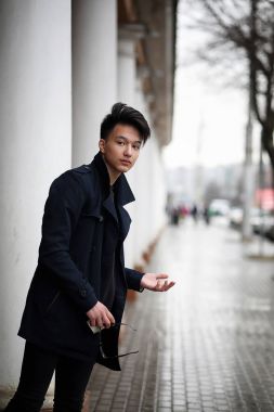 Asya genç adam sokakta bir ceket