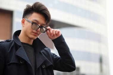 Asya genç adam sokakta bir ceket