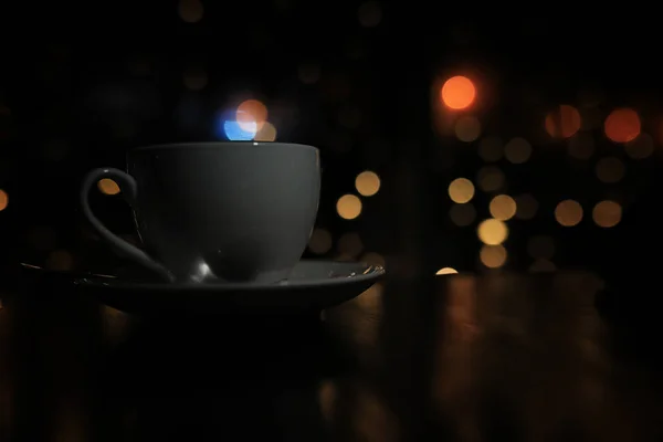 Filiżankę kawy na stole na tle blured z boke koło — Zdjęcie stockowe