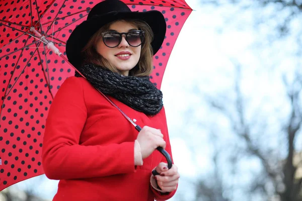 Vacker flicka på en promenad med ett paraply i staden — Stockfoto