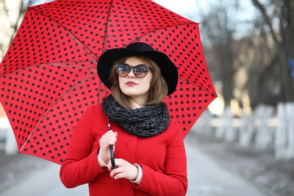 Güzel kız şehirde bir şemsiye ile bir yolda