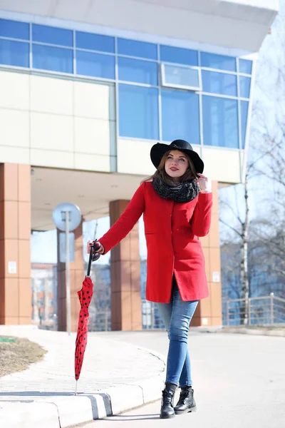 Empresária bonito em um casaco vermelho contra um fundo de vidro — Fotografia de Stock