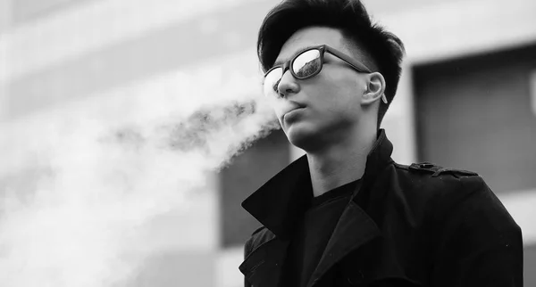 Black White photo of Asian young man outdoors posing