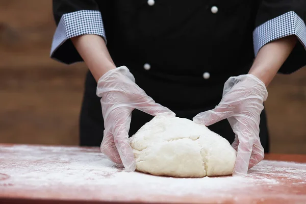 De kok maakt meel voor het bakken op tafel — Stockfoto