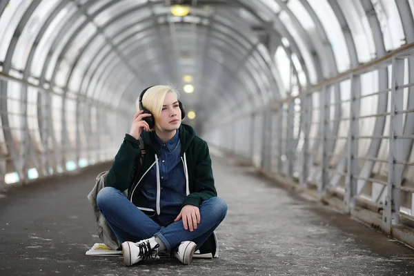Giovane ragazza ascolta la musica in grandi cuffie della metropolitana — Foto Stock
