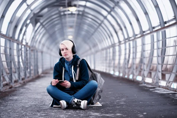 在地铁里大耳机听音乐的年轻学生 — 图库照片