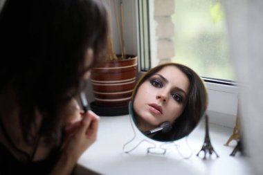 Güzel kız makyaj yapıyor.