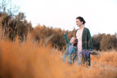 Anne ve kızı yolda yürüyor.