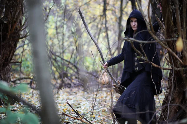 Una mujer con un traje de bruja en un bosque — Foto de Stock