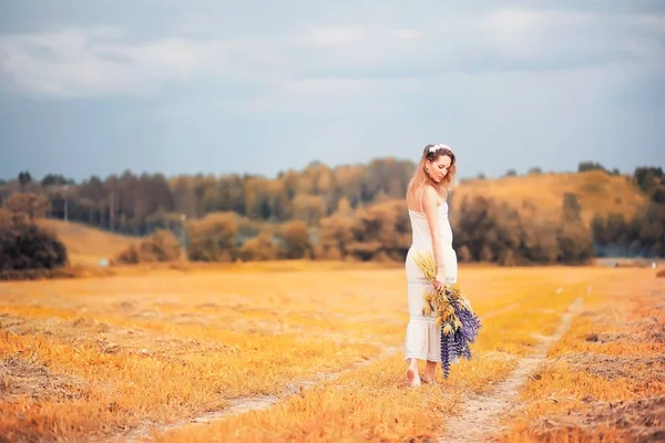 Menina com um buquê de flores no outono — Fotografia de Stock