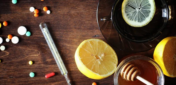 Drogas y pastillas en una mesa de madera. Varios medios para prevenir el frío — Foto de Stock