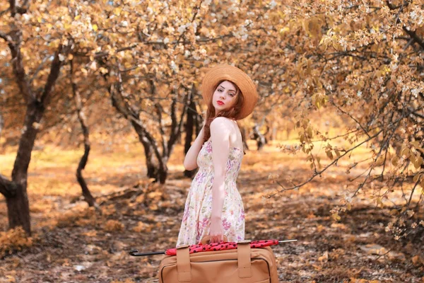 Niña con maleta de cuero para viajar en el parque de otoño a pie — Foto de Stock