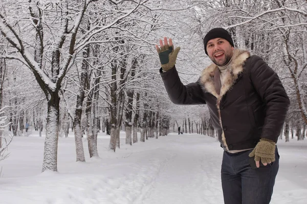 bearded man walking in a winter park