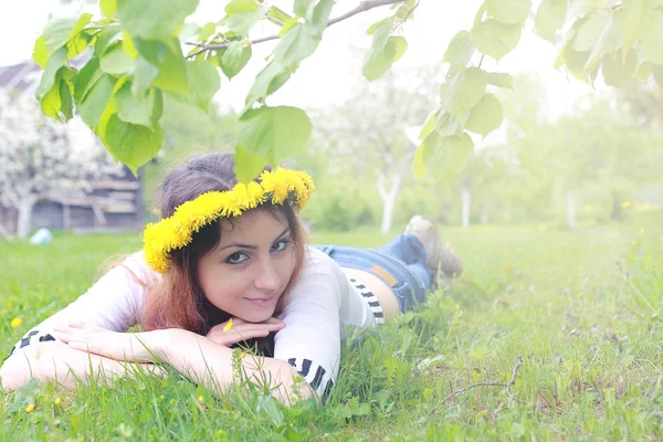 Девушка отдыхает в солнечный день на лугу желтых одуванчиков — стоковое фото
